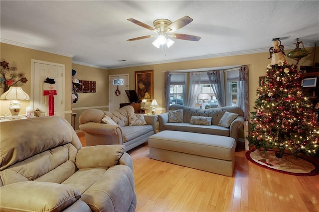 living room featuring ceiling fan, light hardwood / wood-style flooring, and crown molding