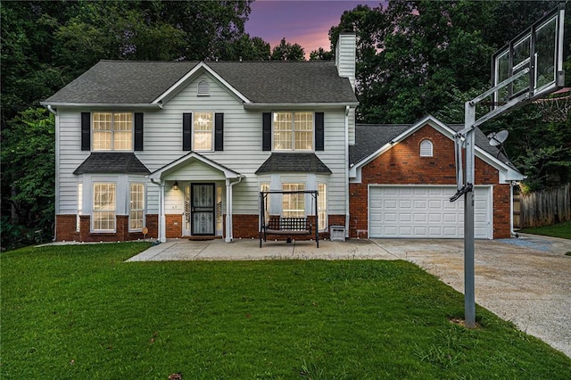 view of front of house with a garage and a yard