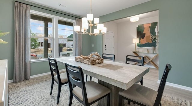 dining room with a chandelier and light wood-type flooring