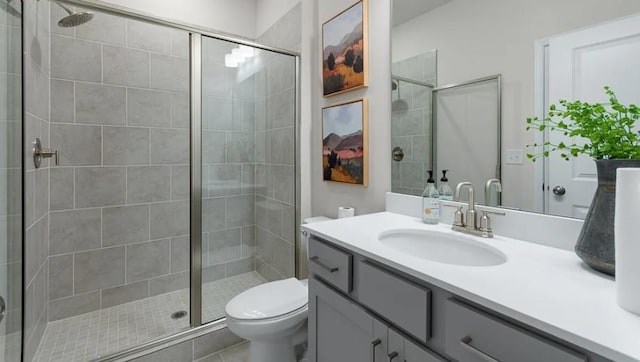 bathroom with a shower with door, tile patterned floors, toilet, and vanity