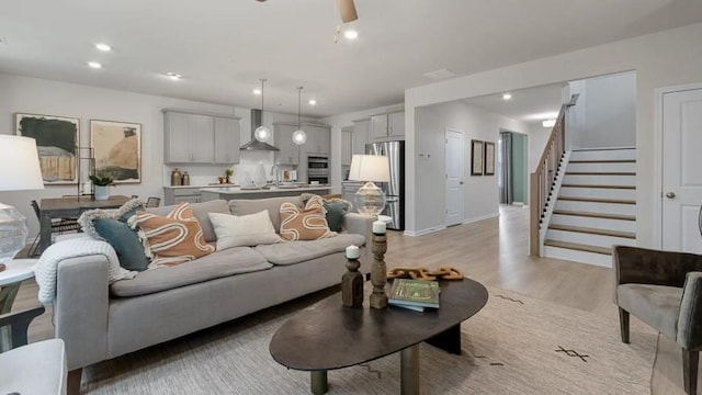 living room with ceiling fan and light hardwood / wood-style floors