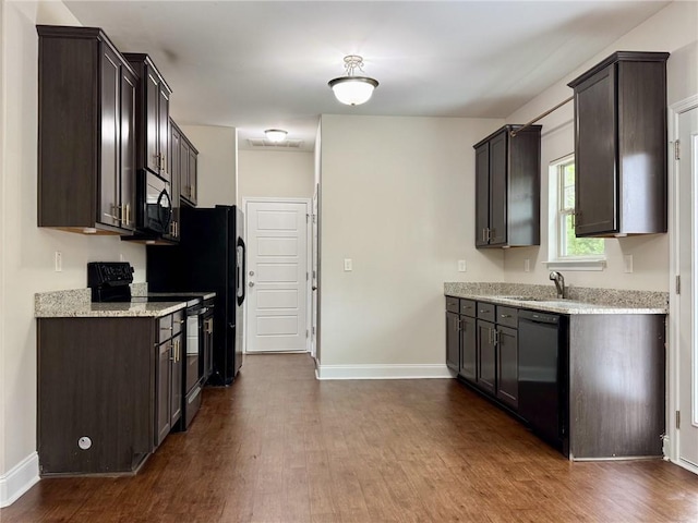 kitchen with a sink, dark brown cabinetry, and black appliances