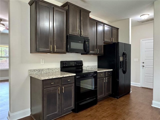 kitchen with visible vents, dark wood-type flooring, baseboards, dark brown cabinetry, and black appliances