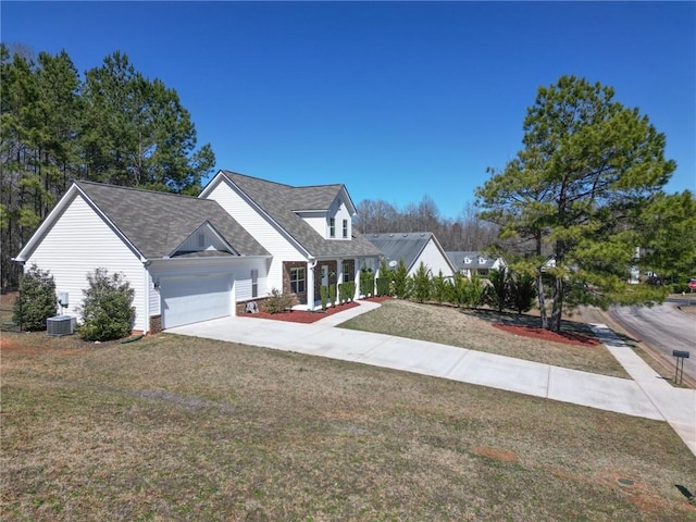 view of front of property with a front yard, concrete driveway, central AC unit, and a garage