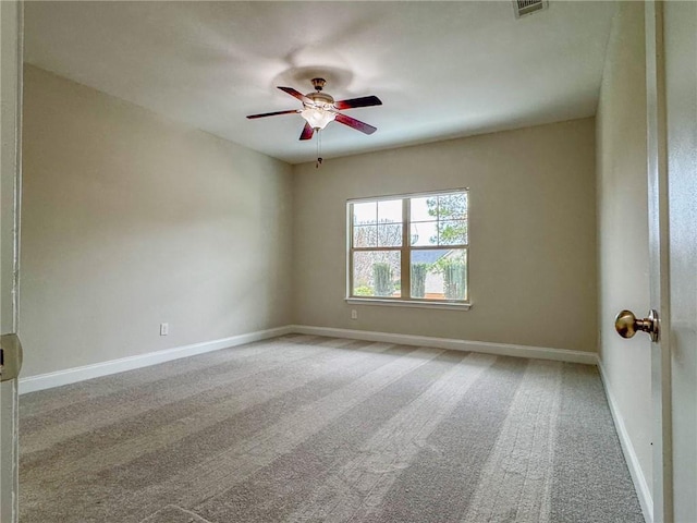 spare room featuring baseboards, light carpet, visible vents, and a ceiling fan