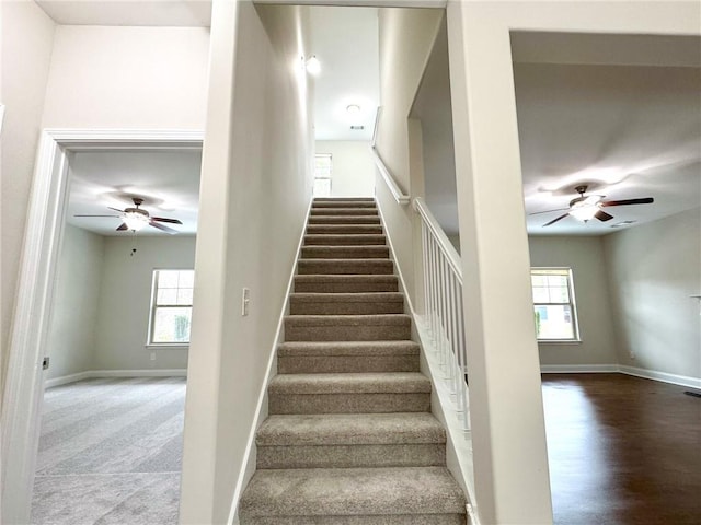 stairway featuring wood finished floors, baseboards, and ceiling fan