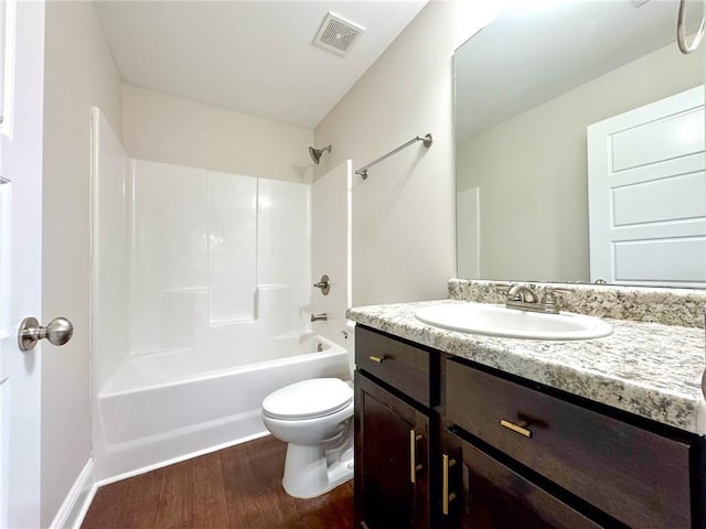 bathroom featuring visible vents, toilet, shower / washtub combination, wood finished floors, and vanity