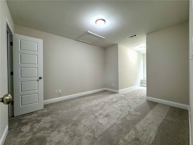 unfurnished room featuring baseboards, visible vents, attic access, and carpet