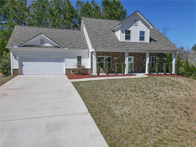 view of front of house with a garage, brick siding, concrete driveway, and a front yard