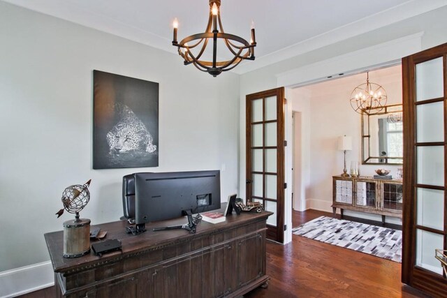 home office with dark wood-type flooring, ornamental molding, and a notable chandelier