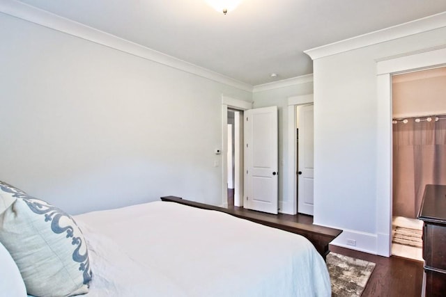 bedroom featuring ornamental molding and dark wood-type flooring