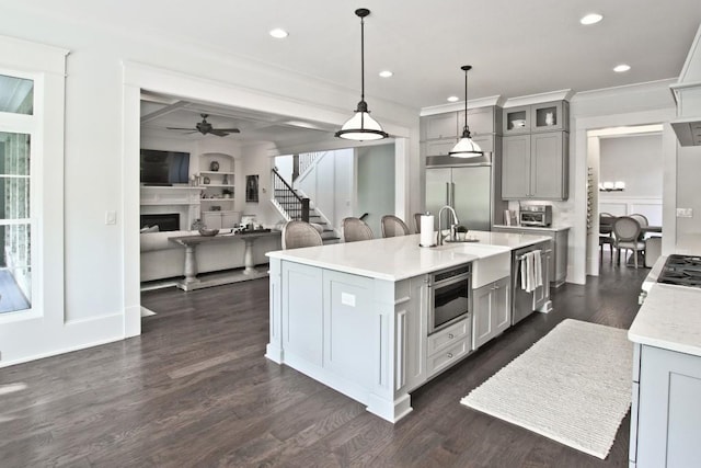 kitchen featuring pendant lighting, ceiling fan, built in appliances, gray cabinets, and dark hardwood / wood-style floors