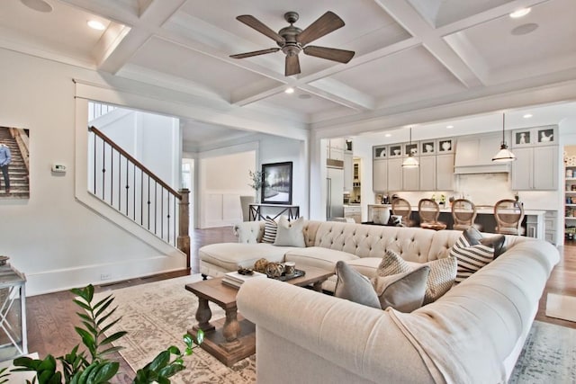 living room with light hardwood / wood-style flooring, ceiling fan, coffered ceiling, and beamed ceiling