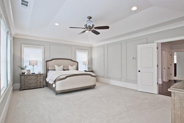 bedroom with a tray ceiling, ceiling fan, and light colored carpet