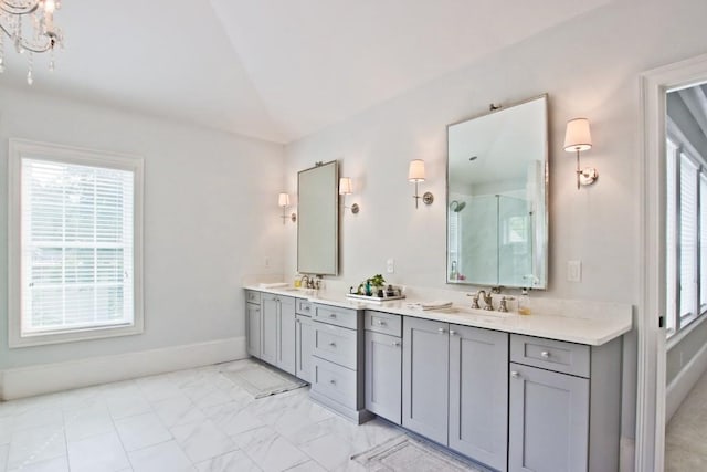 bathroom featuring a healthy amount of sunlight, dual bowl vanity, tile flooring, and vaulted ceiling