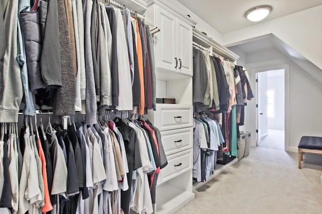 walk in closet featuring light carpet