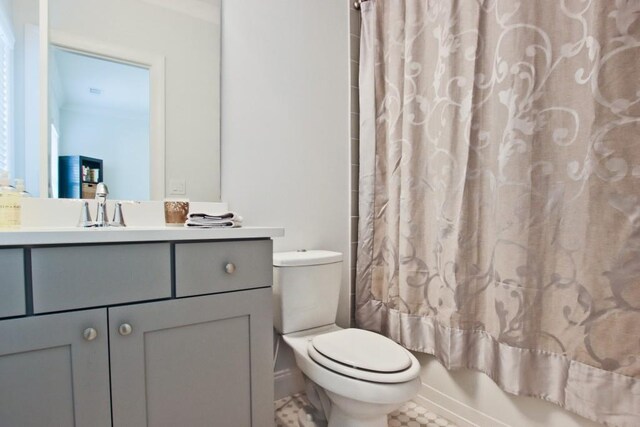 full bathroom with vanity, tile floors, shower / tub combo with curtain, and toilet