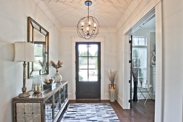 entryway featuring an inviting chandelier, ornamental molding, and dark hardwood / wood-style floors