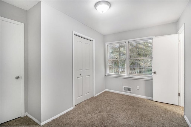 unfurnished bedroom featuring a closet and carpet floors