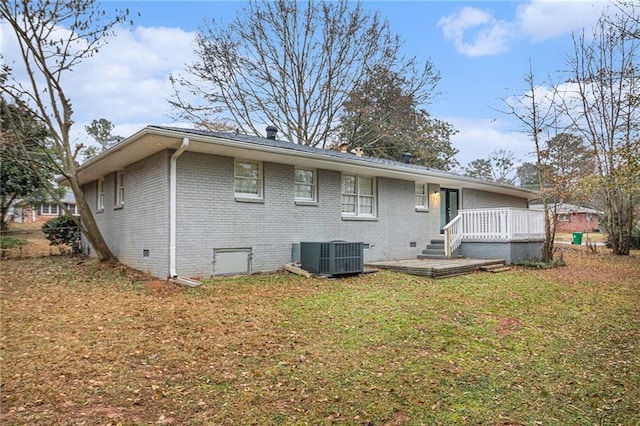 rear view of house featuring cooling unit, a yard, and a wooden deck