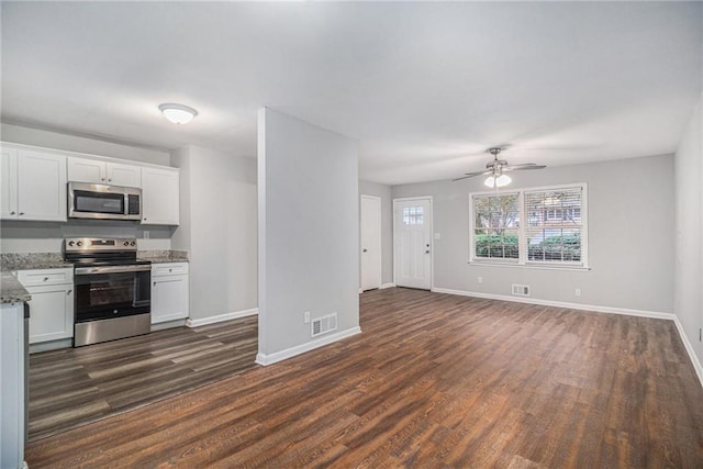 kitchen featuring white cabinetry, dark hardwood / wood-style flooring, light stone countertops, and appliances with stainless steel finishes