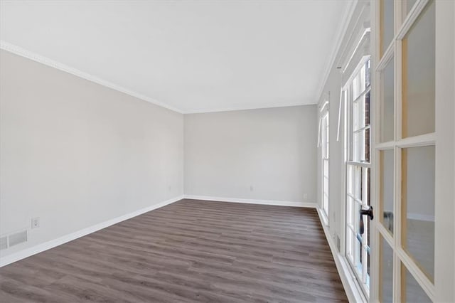 spare room featuring visible vents, baseboards, dark wood-style flooring, ornamental molding, and french doors