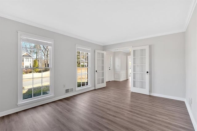 empty room featuring baseboards, visible vents, dark wood-style flooring, ornamental molding, and french doors