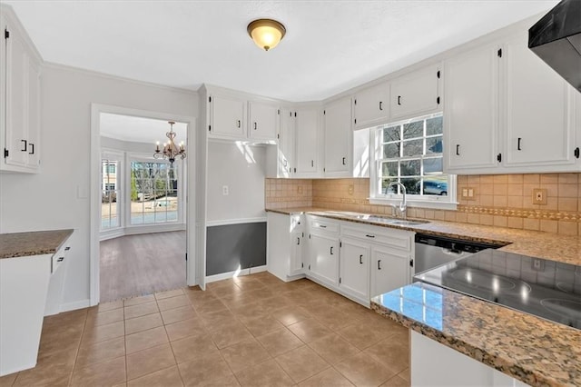 kitchen with a sink, tasteful backsplash, range hood, and white cabinetry