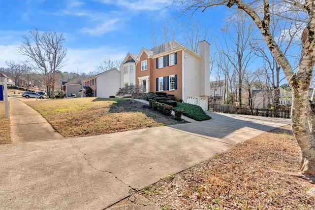 view of front of property with a front yard, fence, an attached garage, a chimney, and concrete driveway