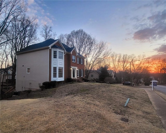 property exterior at dusk with a yard