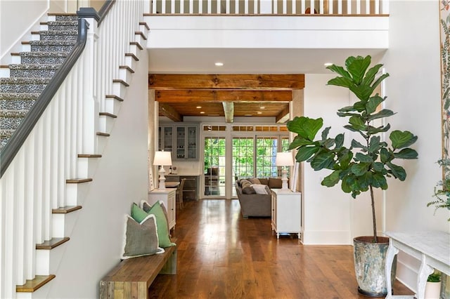 staircase with wood finished floors, beamed ceiling, and recessed lighting