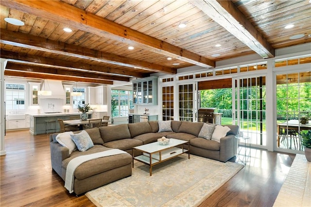 living area with wood ceiling, beamed ceiling, wood finished floors, and recessed lighting
