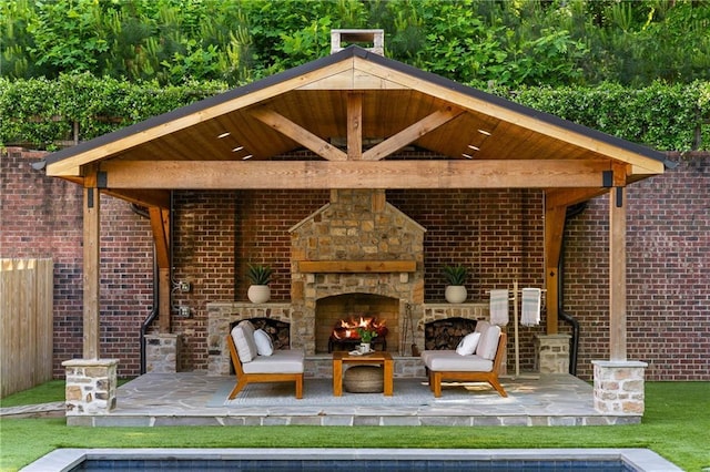 view of patio / terrace featuring an outdoor stone fireplace and a gazebo