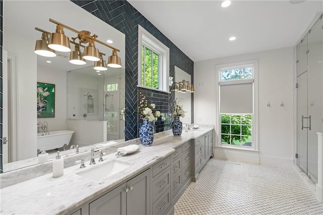 full bath with a stall shower, healthy amount of natural light, double vanity, a freestanding bath, and recessed lighting