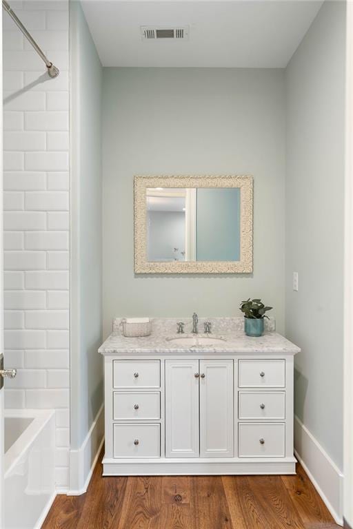 bathroom featuring baseboards, vanity, and wood finished floors