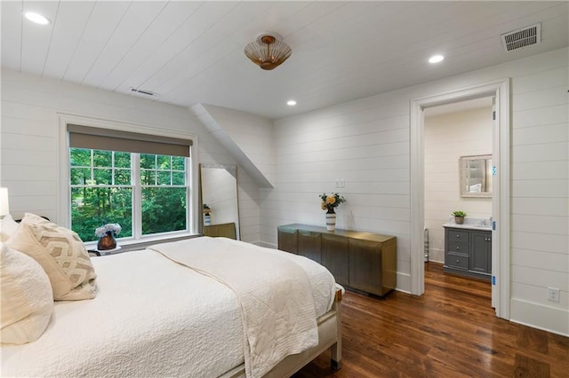 bedroom featuring dark wood-style floors, wood walls, recessed lighting, and ensuite bathroom