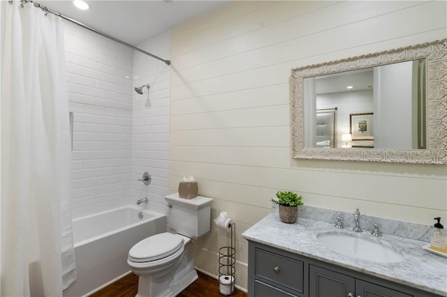 full bathroom featuring wood finished floors, toilet, shower / bath combo with shower curtain, vanity, and recessed lighting