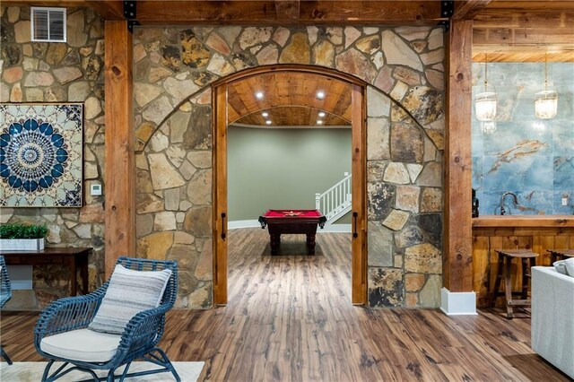 game room with pool table, arched walkways, wood finished floors, and beam ceiling