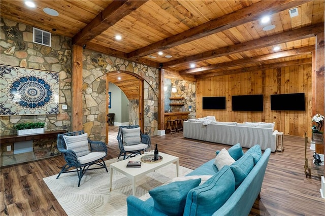 living area featuring arched walkways, wooden ceiling, beamed ceiling, wooden walls, and wood finished floors