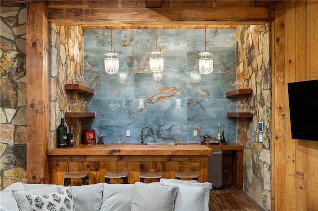 indoor wet bar with wood finished floors, dishwasher, and wood walls