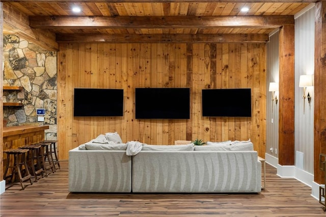 living area featuring wood ceiling, beamed ceiling, wood walls, wood finished floors, and baseboards