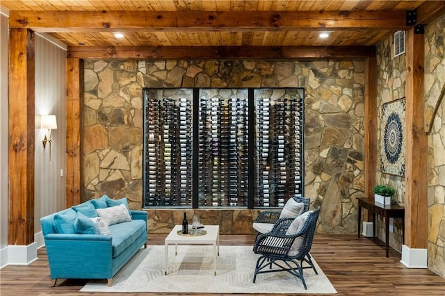 wine cellar with wood ceiling, wood finished floors, beam ceiling, and baseboards