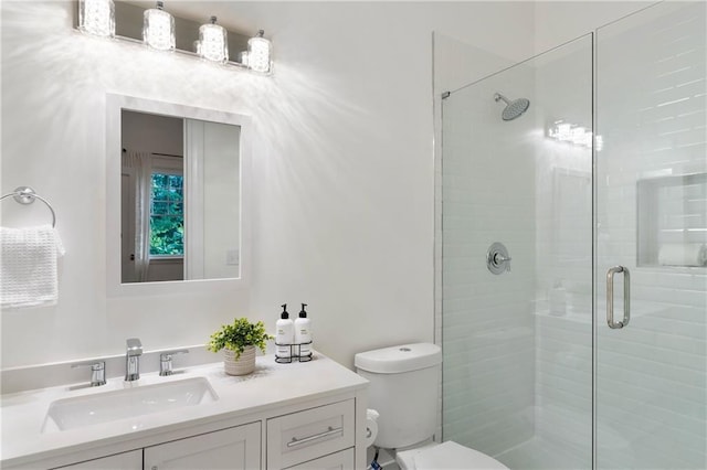 full bath with a stall shower, toilet, and vanity