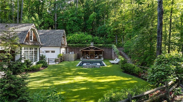 view of yard featuring an outdoor structure and a wooded view