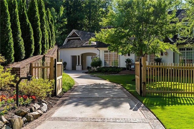 view of front facade with stucco siding, concrete driveway, and a shingled roof