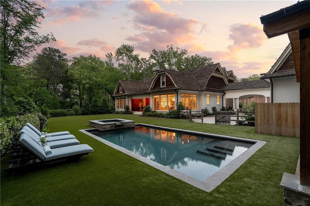 back of house with a pool with connected hot tub and a patio area