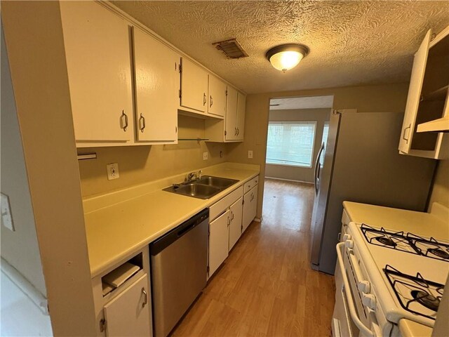 2834 Royal Path Ct, Decatur, GA 30030 - kitchen with white gas stove, light wood-style flooring, visible vents, dishwasher, and a sink