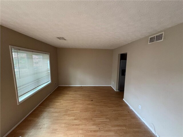 2834 Royal Path Ct, Decatur, GA 30030 - spare room featuring light wood-type flooring, baseboards, visible vents, and a textured ceiling