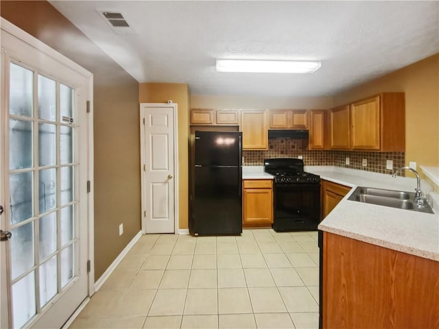 kitchen with backsplash, black appliances, sink, light tile patterned floors, and a healthy amount of sunlight