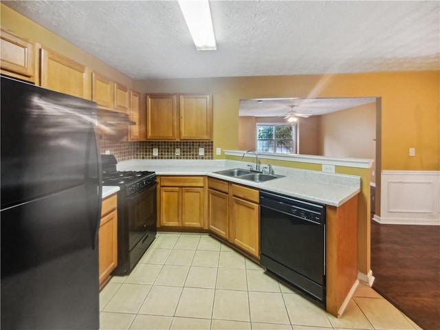 kitchen with ceiling fan, sink, backsplash, kitchen peninsula, and black appliances